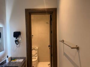 a bathroom with a toilet and a door to a shower at Apartment in As Salam Rd in Medina