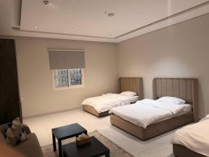a hotel room with two beds and a couch at Apartment in As Salam Rd in Medina