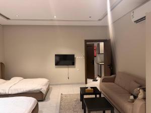 a living room with a couch and a flat screen tv at Apartment in As Salam Rd in Medina