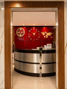 a lobby with a counter with a clock on the wall at Estadía El Dorado in Bogotá