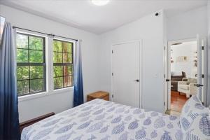 a bedroom with a bed and two windows at Private Dock, Boat Launch, Fire Pit & Lake Views in Sunrise Beach