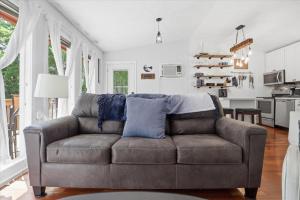 a living room with a couch and a kitchen at Private Dock, Boat Launch, Fire Pit & Lake Views in Sunrise Beach