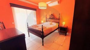 a bedroom with a bed in an orange room at Casa dos Pomares in Figueira da Foz