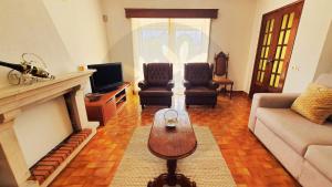 a living room with a couch and a fireplace at Casa dos Pomares in Figueira da Foz