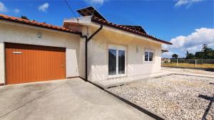 a house with an orange door on a driveway at Casa dos Pomares in Figueira da Foz