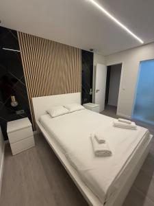 a bedroom with a large white bed with two towels on it at Casa Noir Luxury 3BR Apartment 2 Baths Near Lisbon & Sintra in Queluz