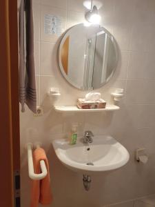 a bathroom with a sink and a mirror at Hotel Gasthaus zur Krone in Gochsheim +1 photo