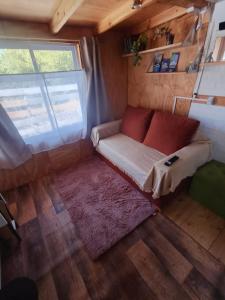 a couch in the middle of a tiny house at Casa Nido Tiny House in El Chalten