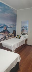 two beds in a room with a picture on the wall at Hotel Alvorada do Sol in São Paulo