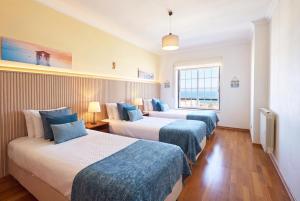 a hotel room with three beds and a window at Ericeira Sunset Lifestyle I in Ericeira +37 photos