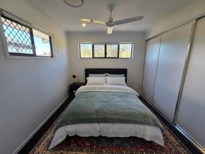 a bedroom with a bed and two windows at Private Room with Queen Bed & Bathroom in Bellbird Park