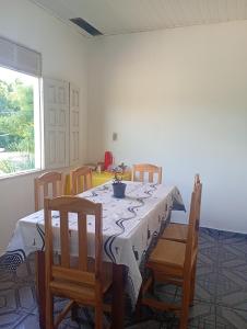 a dining room with a table and chairs and a window at Pousada kurasi alter 02 in Santarém +1 photo