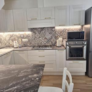 a kitchen with white cabinets and a stove top oven at Casa Sant'Antonio Dimora Storica in Tarquinia