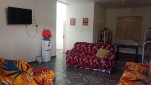 a living room with a red couch and a tv at Pousada kurasi alter 02 in Santarém