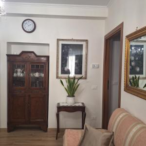 a living room with a couch and a clock on the wall at Casa Sant'Antonio Dimora Storica in Tarquinia