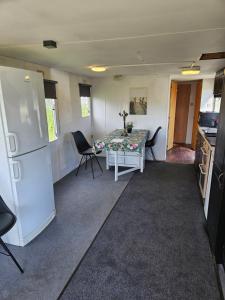 a kitchen with a table and a white refrigerator at Arrie in in Vellinge