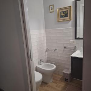 a white bathroom with a toilet and a sink at Casa Sant'Antonio Dimora Storica in Tarquinia