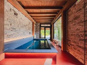 a swimming pool in a room with a brick wall at Ca' Bella Hospitality in Vignole Borbera