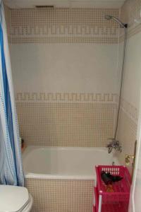 a bathroom with a bath tub and a toilet at Dénia Palm Garden Apartment Pool & Parking in Denia +12 photos