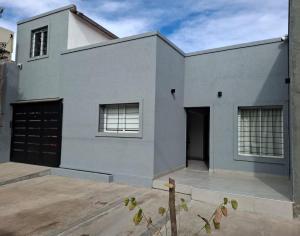 a gray house with a garage at Casa Prado in San Fernando del Valle de Catamarca