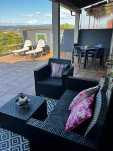 a patio with couches and a table and chairs at Caneliña in Ourense