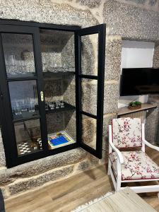 a room with a chair and a glass window at Caneliña in Ourense