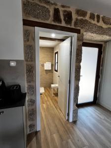 a room with a stone wall and a door to a bathroom at Caneliña in Ourense +56 photos