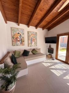 a living room with a couch and a flat screen tv at Villa Majora - Piscina climatizada in Tuineje
