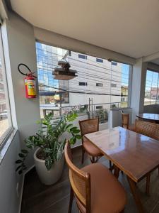 a dining room with a table and chairs and a large window at Hotel Cabana in Parauapebas
