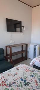 a bedroom with a bed and a desk with a television at Cacique Room 2 in Playa Hermosa