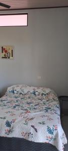 a bed with a quilt on it in a bedroom at Cacique Room 2 in Playa Hermosa +1 photo