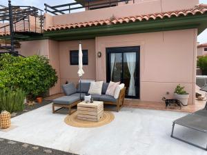 a patio with a couch and a coffee table at Mi Casa in Majanicho