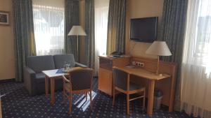 
a living room with a chair and a desk at Hotel-Cafe Rathaus in Bad Abbach
