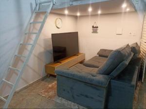 a living room with a ladder and a couch and a television at Estúdio 800m do Buriti Shopping in Aparecida de Goiânia +16 photos