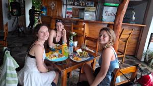 three women sitting at a table eating food at exotic island ometepe in Altagracia +5 photos