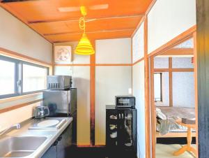 a kitchen with a sink and a microwave at Apt南熱海-網代 in Atami