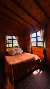 a bedroom with a bed in a room with windows at Glamping Store in Guatavita