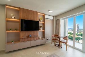 a living room with a television and a table and chairs at Studio in Condo with Pool and Gym MSU0906 in Governador Valadares
