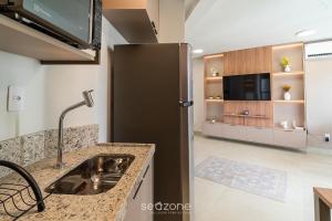a kitchen with a sink and a black refrigerator at Studio in Condo with Pool and Gym MSU0906 in Governador Valadares +4 photos
