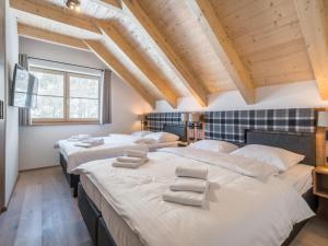 three beds in a room with wooden ceilings at Donnersbach Lodge in Donnersbachwald