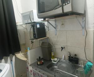 a kitchen counter with a sink and a microwave at Estúdio 800m do Buriti Shopping in Aparecida de Goiânia