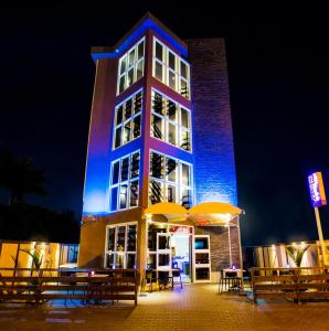 a tall building with tables and umbrellas at night at Q-Inn Boutique Hotel in Paramaribo