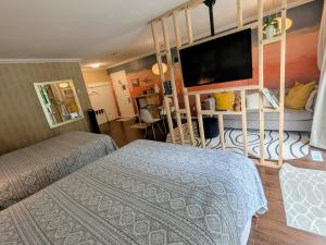 a bedroom with two beds and a flat screen tv at Evergreen Bed & Breakfast in Hope