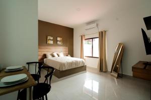 a bedroom with a bed and a table and chairs at La Palma Experience in Panama City