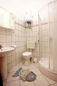 a bathroom with a toilet and a sink and a shower at Apartments by the sea Sevid, Trogir - 9468 in Sevid