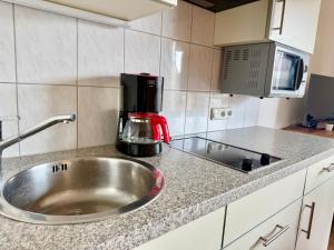 a kitchen counter with a sink and a coffee maker at Apartment Karawankenblick with Lake View - Free Parking in Pörtschach am Wörthersee +151 photos