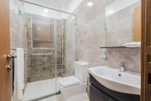 a bathroom with a shower toilet and a sink at Rolling in Nairobi