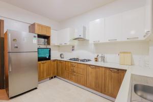 a kitchen with wooden cabinets and a stainless steel refrigerator at Rolling in Nairobi
