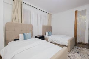 a hotel room with two beds and a couch at Rolling in Nairobi