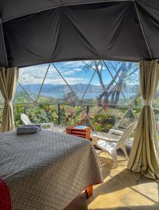ein Schlafzimmer mit einem Bett und einem großen Fenster in der Unterkunft Morpho Glamping in Nuevo Arenal